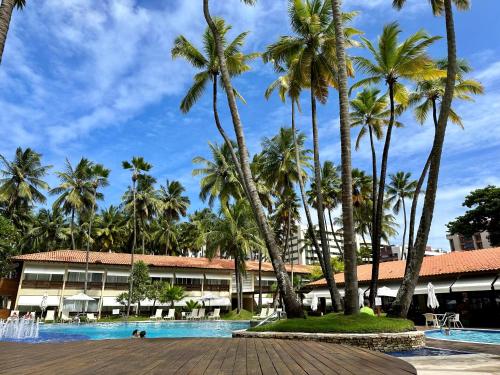 马塞约Jatiuca Suítes Resort FLAT的棕榈树和游泳池度假村