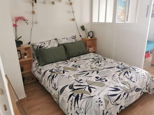 戛纳Cannes Isola Bella entre mer et montagne的一间卧室配有一张带黑白色棉被的床