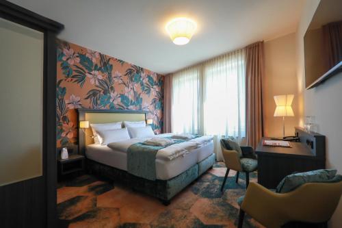 吕本瑙SPREE. Hotel am Hafen的配有一张床和一张书桌的酒店客房