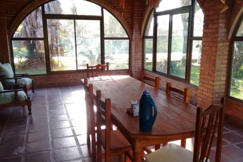 绍斯维乔La casa del Rio en Sauce Viejo - Santa Fe-的一间带木桌和窗户的用餐室