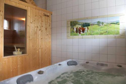 Arc-sous-CiconGîte l'essentiel的浴室设有浴缸,并展示了牛的画面