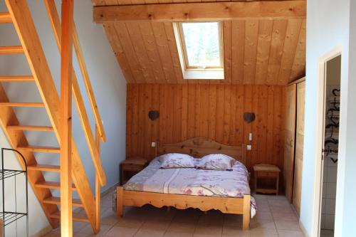 Arc-sous-CiconGîte l'essentiel的一间卧室设有一张木天花板床。