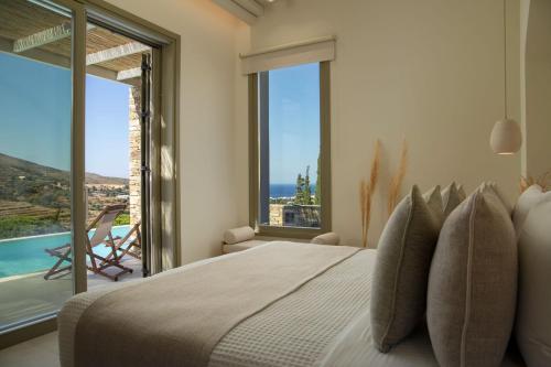 安德罗斯Casa Di Fiori Andros Suites的一间卧室设有一张大床,享有海景