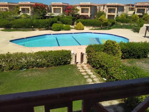 Al Ḩammām4 bedroom Villa with private terrace, pool, and garden的阳台享有游泳池的景致。