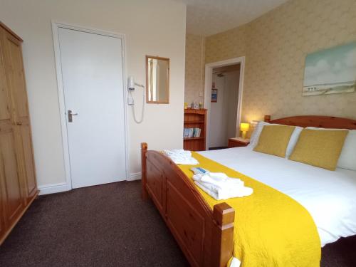 斯凯格内斯Brackenhurst Guest House的一间卧室配有一张带黄色毯子的大床