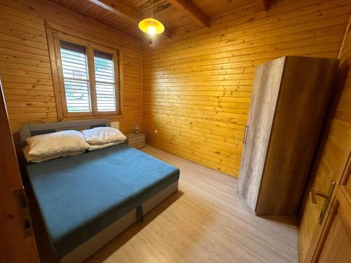 上塔尔卡尼Virág Apartman的木制客房内的一间卧室,配有一张床