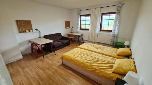 斯洛文尼亚格拉代茨Apartma pri babici的一间卧室配有一张床、一张沙发和一张桌子