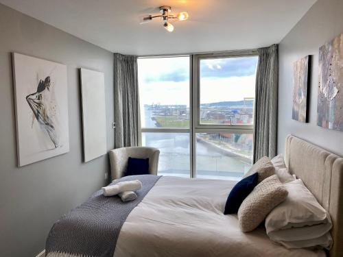 贝尔法斯特Titanic and Sea View Belfast 2 bedroom Apartment City Centre的一间卧室设有一张床和一个大窗户