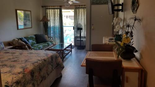 基黑Maui Diver's Dream at Kihei Bay Surf的一间卧室配有一张床、一张沙发和一张桌子