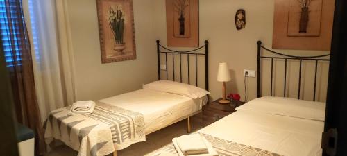 圣玛丽亚港Mis Tres Centenarios的一间卧室配有两张床和一盏灯
