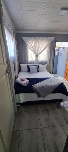 比勒陀利亚Cozy Little Nest的一间卧室设有一张大床和窗户