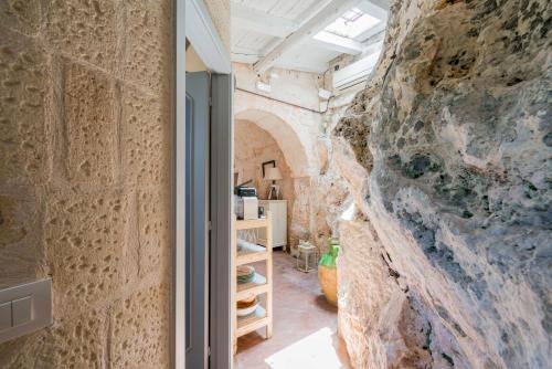 奥斯图尼La Lamia 1864 by Rentbeat的一间设有石墙和一扇开放式门的房间