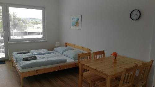 MilešovApartmány Orlík - Loužek的一间卧室配有一张床、一张桌子和闹钟