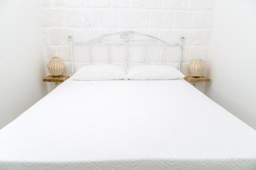 莫诺波利Borgo Albergo Capozzi 39的白色的床、白色床单和枕头