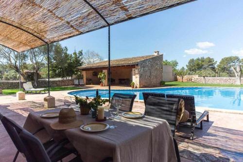 阿尔盖达Finca Cas Contador Mallorca的游泳池旁的餐桌和椅子