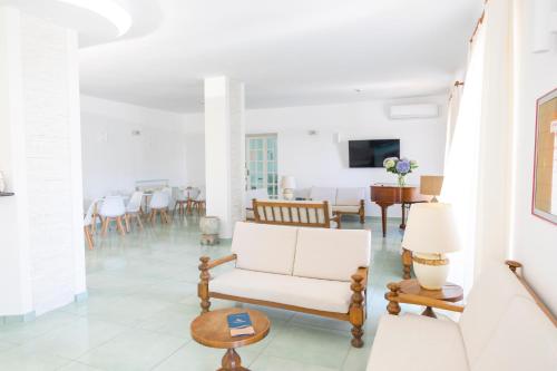 伊斯基亚拉卢纳酒店的客厅配有白色的沙发和椅子