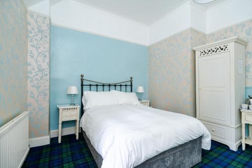洛亨黑德Mansewood Country House的一间卧室配有一张带蓝色墙壁的大床