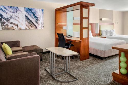 Bellport长岛布莱克海文春季山丘套房酒店的配有一张床和一张书桌的酒店客房