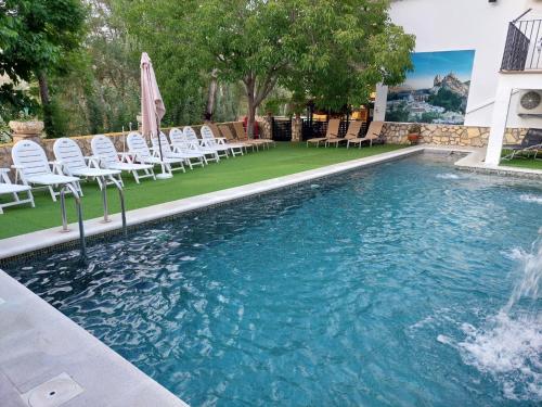 卡斯特里尔Casa el angel的一个带白色椅子的游泳池和一个喷泉