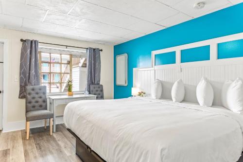 汉普顿Royal Crest Inn - Hampton Beach的卧室配有一张白色大床和一张书桌