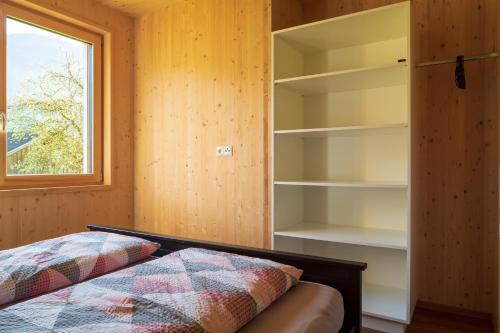 施科佩尔瑙Bergreich Appartement 2的一间卧室设有床、窗户和书架
