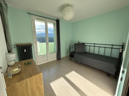 艾克斯莱班Appartement T3 Aix les bains的一间卧室配有一张床、一张桌子和一个窗户。
