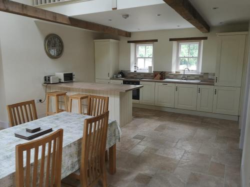 卡洛Lovely 3-Bed House at Clashganny Mill Borris的厨房配有桌椅和水槽。