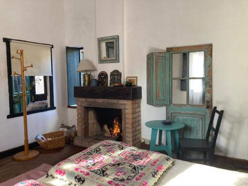 科洛尼亚-德尔萨克拉门托Rincón Colonial的客房设有壁炉、床和桌子。