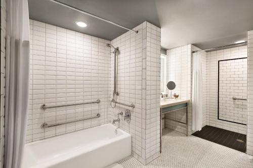 绿湾Hotel Northland, Autograph Collection的白色的浴室设有浴缸和水槽。