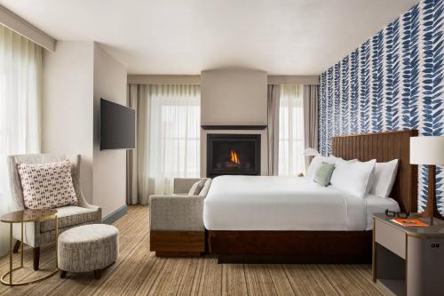 绿湾Hotel Northland, Autograph Collection的酒店客房配有一张床和一个壁炉。