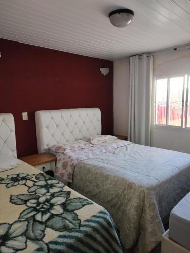 圣若泽杜斯皮尼艾斯Casa Térrea Oliveira inteira的一间卧室设有两张床和窗户。