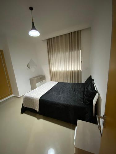 艾西拉ASILAH MARINA GOLF的一间卧室设有一张黑色的床和一个窗户。