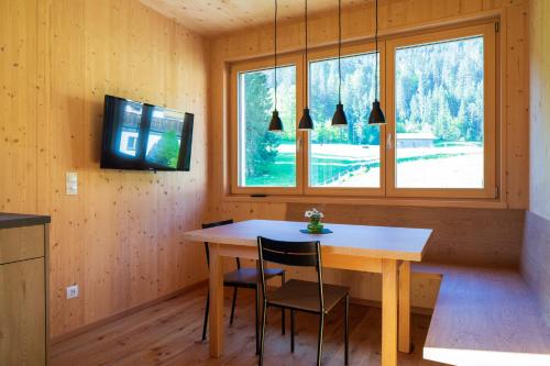 施科佩尔瑙Bergreich Appartement 4的一间带木桌和窗户的用餐室