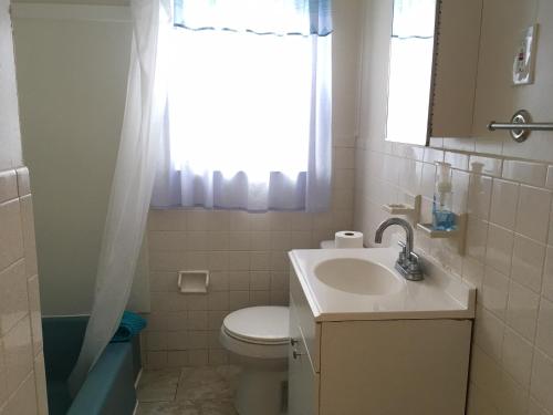 大洋城Blue Haven Apartments的一间带水槽和卫生间的浴室以及窗户。
