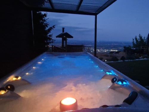 霍茨科波霍尔耶Panoramic view Cottage house - Heaven的热水浴池配有蜡烛和两盏灯