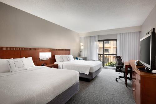 迈尔斯堡珊瑚角迈尔斯堡万怡酒店 的酒店客房设有两张床和一台平面电视。