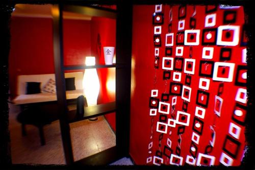 莱佩Pensión El Alamo的一间设有红色墙壁、一张床和一个窗户的房间