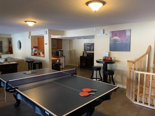 舍伍德帕克Dragonfly Inn Loft & Walkout Suites的客厅中央的乒乓球桌