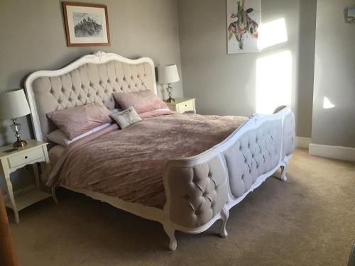 雷克瑟姆Plas Bostock Farm的卧室配有带粉红色枕头的大型白色床
