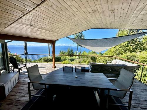 半月湾Barooga: Stunning View Home in Halfmoon Bay, Canada的露台设有桌椅