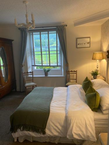 哈罗盖特Bewerley Hall farm的一间卧室设有一张大床和一个窗户。