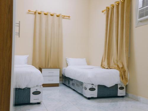 塞拉莱أجاويد Ajaweed的一间卧室配有两张床和窗帘