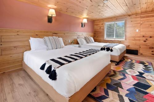 威尔明顿Wolfjaw Lodge的木墙客房的两张床