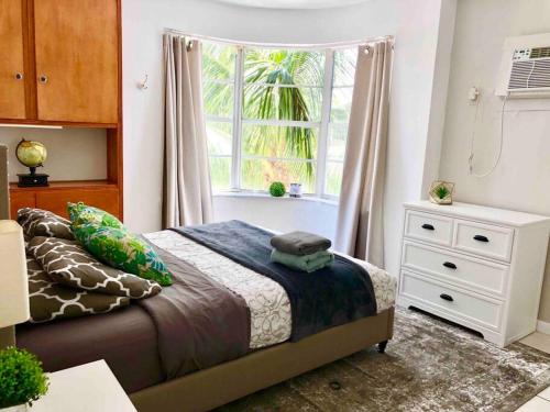 迈阿密海滩JUST 1 BLOCK FROM THE BEACH!的一间卧室设有一张床和一个窗口