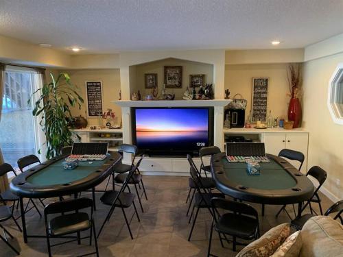 舍伍德帕克Dragonfly Inn Walkout Suites的客厅设有两张桌子和一台大电视