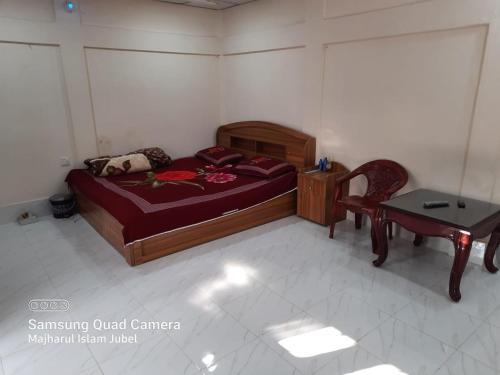巴纳内拉斯Sunapur Mini Resort Sylhet的卧室配有1张床、1张桌子和1把椅子