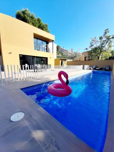 NáqueraExperience Valencia Bnb - Luxury Apartment Naquera Chalet 298 con Piscina的水中一个粉红色天鹅的游泳池