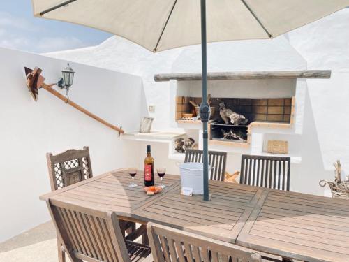 亚伊萨Casa Gercko 2的甲板上配有带遮阳伞的木桌