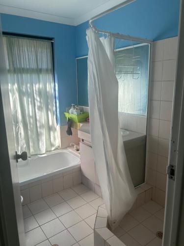 珀斯Single room share bathroom and kitchen的带浴缸和淋浴帘的浴室