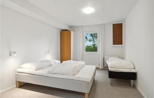 布罗斯特Cozy Home In Brovst With Kitchen的白色的客房设有两张床和窗户。